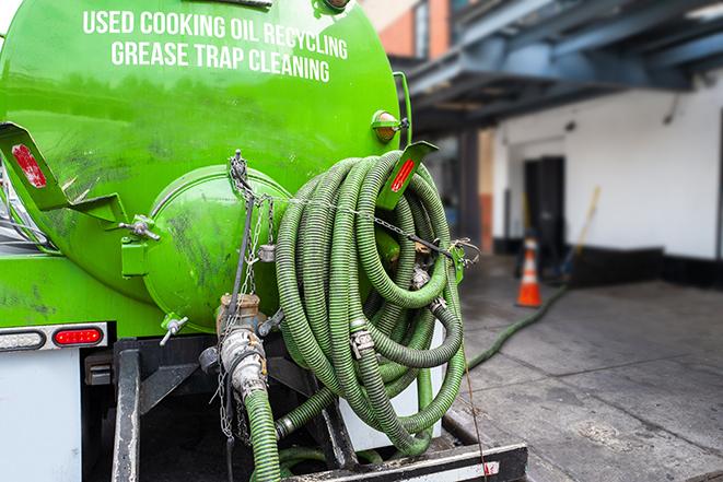 grease trap pumping truck servicing a restaurant in Farmdale